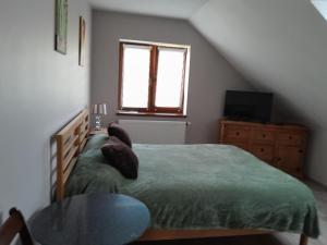 a bedroom with a bed and a table and a window at Pod Żurawiem in Bóbrka +2 photos