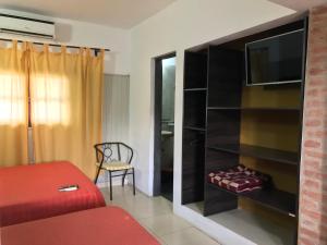 ミナ・クラベロにあるApart hotel La Posaditaの赤いベッドとテレビのある寝室