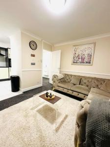 a living room with a couch and a table at Ibate Apartment, Basildon Essex in Nevendon