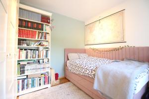a bedroom with a bed and a book shelf with books at Zagreb home in Maksimir