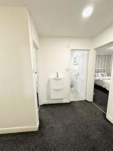 a white bathroom with a sink and a bedroom at Ibate Apartment, Basildon Essex in Nevendon