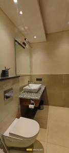 a bathroom with a toilet and a sink at The Cozy Acorn Resort in Patwa Dunga