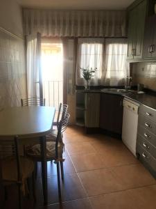 a kitchen with a table and a table and chairs at Apartamento Dúplex Casa Jares in Caspe
