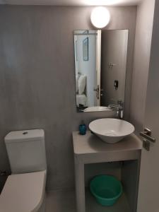 a bathroom with a sink and a toilet and a mirror at Thalassa4 in Andros