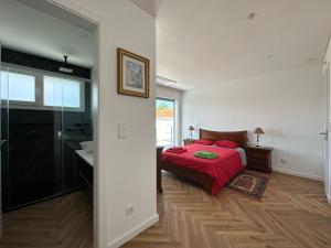 - une chambre avec un lit rouge et une salle de bains dans l'établissement Maison bord mer près de le Lisbonne, à Charneca 10 autres photos