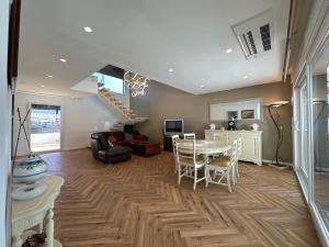 un salon avec une table et des chaises et un escalier dans l'établissement Maison bord mer près de le Lisbonne, à Charneca
