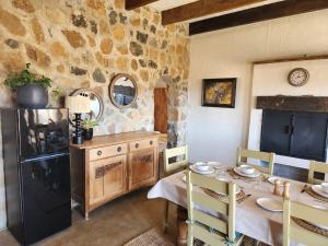 una cucina con un tavolo e un muro di pietra di Dragons Landing Guest House a Hartlea