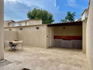 a patio with a table and chairs in front of a house at T3 avec jardin, proche plage & commodités in Fos-sur-Mer