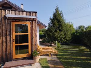 een houten schuur met een bank in een tuin bij Apartman TESLA 29, Veternik in Veternik