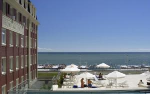 un edificio con una piscina con sombrillas y el océano en Hermitage Hotel en Mar del Plata