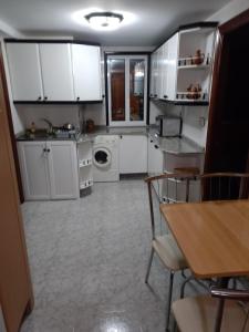 a kitchen with white cabinets and a washing machine at Lage ,Costa da Morte, ruta dos faros, Galicia, playa in Laxe