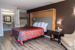 a hotel room with a bed and a chair at Columbus Inn and Suites in Columbus +35 photos