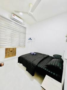 a black bed in a white room with a ceiling at Akasia HomeStay di Bukit Payong, Terengganu in Bukit Payong