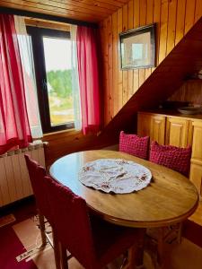 une table à manger avec des chaises et une fenêtre dans l'établissement Vasilije Apartment, à Žabljak