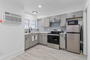 a kitchen with stainless steel appliances and white cabinets at Studio Orlando Rental Kitchen & Fast Wi-fi in Orlando +7 photos