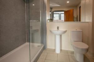 a bathroom with a toilet and a sink and a shower at Dockside Aparthotel, Best Western Signature Collection in Liverpool +84 photos