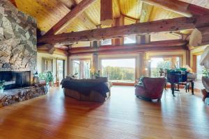 una gran sala de estar con chimenea de piedra. en Cherry Knoll, en Woodland Beach