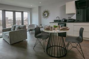 una cucina e un soggiorno con tavolo e sedie di Dockside Aparthotel, Best Western Signature Collection a Liverpool