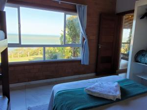 a bedroom with a bed and a large window at Villa Jardim Mar in Anchieta +45 photos