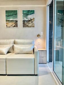 een woonkamer met een witte bank voor een raam bij RN Studio Premium 505 - Vista Mar in Maceió
