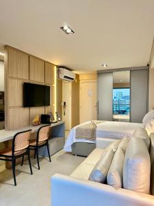 een slaapkamer met 2 bedden, een bureau en een televisie bij RN Studio Premium 505 - Vista Mar in Maceió