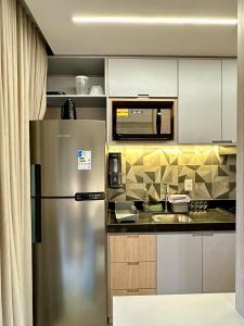 een keuken met een roestvrijstalen koelkast en een magnetron bij RN Studio Premium 505 - Vista Mar in Maceió +13 foto's