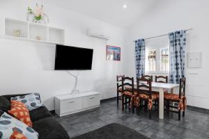 Una sala de estar con un sofá y una mesa con sillas. en Casa Orquidea, en El Palmar