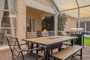 une table et des chaises en bois sur une terrasse dans l'établissement Luxury 4BR Home at Ventura Golf and Country Club, à Orlando 31 autres photos