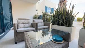 Un patio con sillas y una mesa de cristal. en Ground flor apartament in Turquesa del Mar, Playa Flamenca, en Orihuela