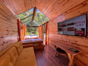 a bedroom with a bed and a tv in a log cabin at Moon River Bungalow in Ayder Yaylasi