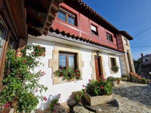 a house with flowers on the side of it at Posada Le Dorat in Santillana del Mar +9 photos