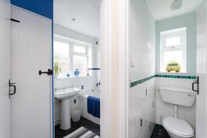 a white bathroom with a toilet and a sink at Quaint 3 bed Cottage in central Dorking with parking in Dorking +38 photos