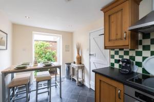 a kitchen with a counter and a table and chairs at Quaint 3 bed Cottage in central Dorking with parking in Dorking