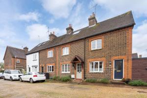 a brick house with cars parked in front of it at Quaint 3 bed Cottage in central Dorking with parking in Dorking