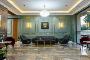 a lobby with a couch and chairs and a table at Royal Sebzor Hotel in Tashkent