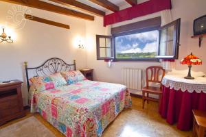 a bedroom with a bed and a table and a window at Posada Le Dorat in Santillana del Mar