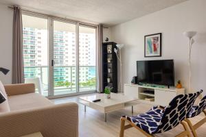 a living room with a couch and a tv at PROMO Komffy Apt with 2 Queen Beds & Ocean View at Tides 7th floor in Hollywood