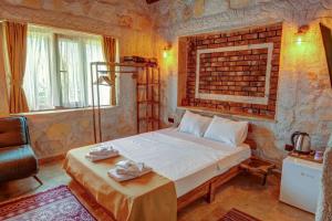 a bedroom with a bed and a brick wall at Ceran Stone House in Nevsehir