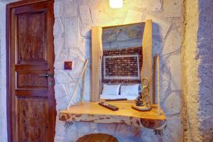 a room with a mirror on a stone wall at Ceran Stone House in Nevsehir