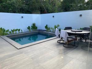 a patio with a table and a swimming pool at Casa Kaan, Senderos, Mayakoba in Playa del Carmen