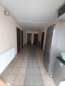 a kitchen with a refrigerator and a tile floor at Motel Ketmia in Plecka Dąbrowa