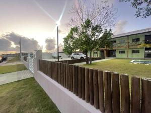 einen Zaun vor einem Gebäude mit einem Hof in der Unterkunft Jacuipe Country in Campos