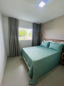 ein Schlafzimmer mit einem Bett mit einer grünen Bettdecke und einem Fenster in der Unterkunft Jacuipe Country in Campos + 15 Fotos
