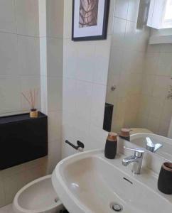 a white bathroom with a sink and a mirror at 19gradini in Putignano