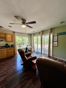 a living room with a ceiling fan and a table at Hidden Lake Campground and Resort in Hot Springs