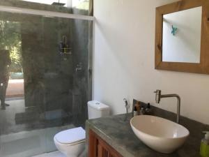 a bathroom with a sink and a toilet and a shower at Quartos em sítio exuberante in Barra Grande