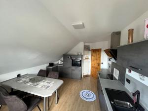 a living room with a table and a kitchen at Wohnung in Steimel in Steimel
