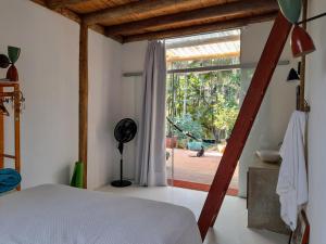 a bedroom with a bed and a large window at Quartos em sítio exuberante in Barra Grande +34 photos