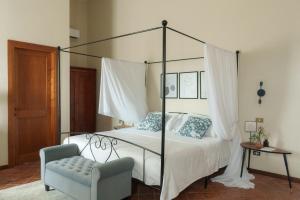 a bedroom with a canopy bed and a chair at Relais di campagna la polledrara in Paliano +66 photos