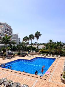 a large swimming pool with people in the water at Beach House Apartment in Adeje